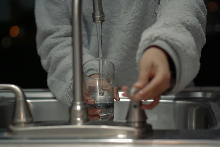 Person getting a glass of water from a sink - Village of Bellaire, Ohio